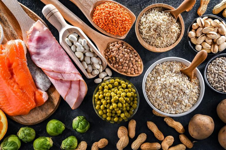 Healthy ingredients including salmon, pork, brown rice, lentils, peas, pistachios, seeds and peanuts with brussels sprouts